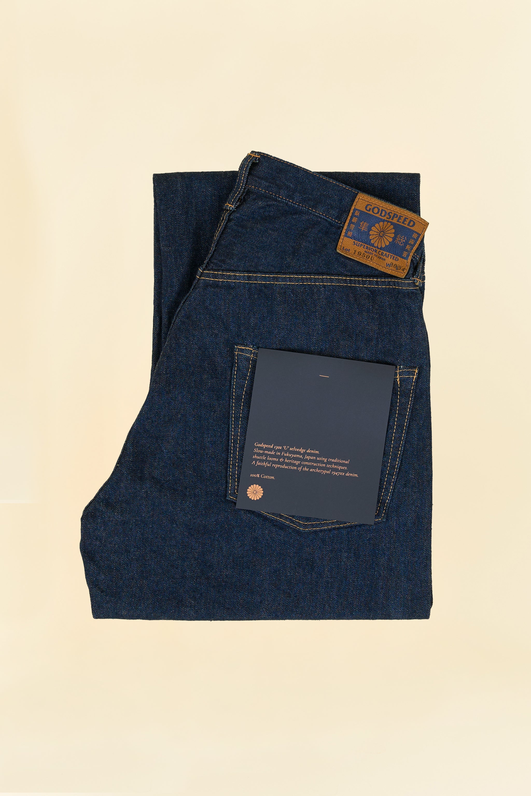 Godspeed 1950 “U” 13oz Wide-Straight Japanese Selvedge Jeans – folded view showing environmentally printed label and leather patch
